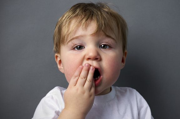 Child with hand over mouth