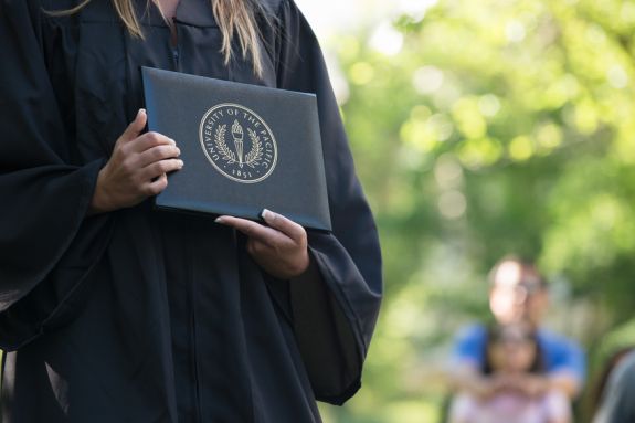 A Graduate holding a diploma cover
