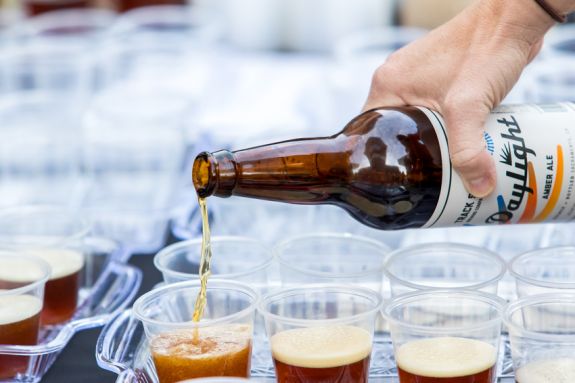 Bottle of beer being poured into cups