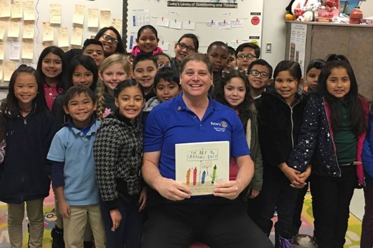 Jim Dugoni, a development officer with Pacific’s Arthur A. Dugoni School of Dentistry, poses with children during the annual Rotary Read-In.
