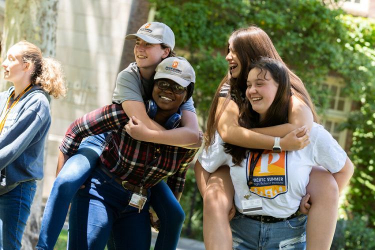 four students standing together smiling