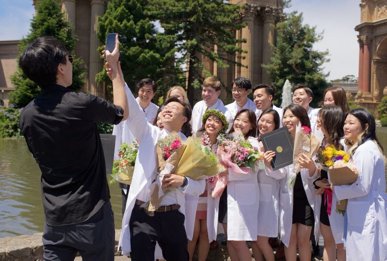 students outside in a group selfie pose at The Palace of Fine Arts